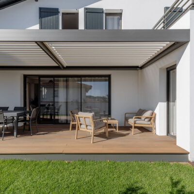 Vue d’une maison contemporaine familiale avec grandes baies vitrées, cuisine ouverte et salle à manger lumineuse donnant sur jardin et piscine.